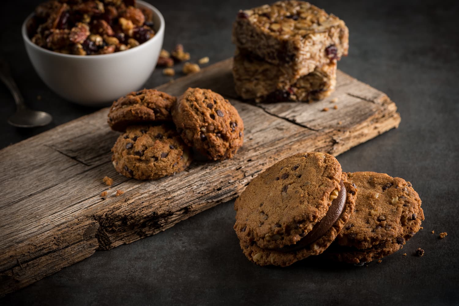 Cookies and a bowl of trail mix on a rustic wood board, dessert platters for catering in Central Louisiana